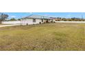 House with large front yard, attached two-car garage, and white vinyl fence at 2413 Crestview Rd, Wimauma, FL 33598