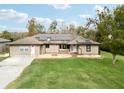 Aerial view of a tan house with a large grassy yard and solar panels at 2609 65Th E St, Bradenton, FL 34208