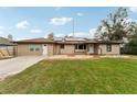 Rear view of tan house with solar panels, stone patio, and grassy yard at 2609 65Th E St, Bradenton, FL 34208