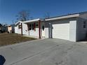 Newly renovated home with a gray exterior, attached garage, and well-maintained lawn at 4841 Zodiac Ave, Holiday, FL 34690