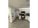 Modern kitchen with white shaker cabinets, granite countertops, and stainless steel appliances at 4841 Zodiac Ave, Holiday, FL 34690