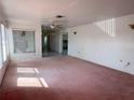 Bright living room with pink carpet and view into kitchen at 10 Golfview S Rd, Rotonda West, FL 33947