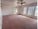 Spacious living room with pink carpet and large windows at 10 Golfview S Rd, Rotonda West, FL 33947