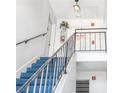 Indoor staircase with blue carpeting and metal railings at 1122 84Th N Ter # C, St Petersburg, FL 33702