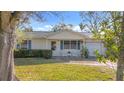 Light beige single story home with a well-maintained lawn and shrubs at 1517 Young Ave, Clearwater, FL 33756