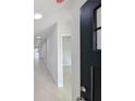 Bright hallway with light tiled floors and black door at 4226 Elwood Rd, Spring Hill, FL 34609