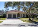 Beautiful home exterior with a three-car garage and manicured lawn at 4520 W Woodmere Rd, Tampa, FL 33609