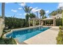 Inviting swimming pool with pergola and lush landscaping at 4520 W Woodmere Rd, Tampa, FL 33609