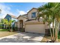 Two-story house with tan exterior, landscaping, and a two-car garage at 529 Vista Ridge Dr, Ruskin, FL 33570