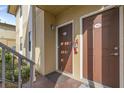 Condo building entry with two brown doors and a fire extinguisher at 10199 Sailwinds S Blvd # I-102, Largo, FL 33773