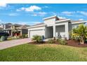 Attractive single-story home with a well-manicured lawn, brick driveway, and lush landscaping at 11312 Gallatin Trl, Parrish, FL 34219