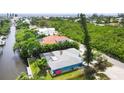 Aerial view showcasing a canal-front home with lush landscaping at 616 Lyons Ln, Longboat Key, FL 34228