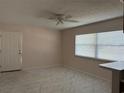 Bright living room featuring tile floors, a ceiling fan, and natural light from a large window at 6177 Chesham Dr # 5, New Port Richey, FL 34653