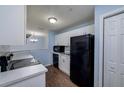 Clean, white kitchen with black appliances and wood floors at 18001 Richmond Place Dr # 835, Tampa, FL 33647