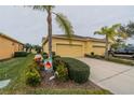 Villa featuring a two-car garage and well-maintained landscaping at 2311 Nottingham Greens Dr # 2311, Sun City Center, FL 33573