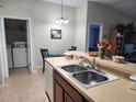 Bright kitchen with double sink, laundry area, and a dining space at 3604 Harvest Orchard Dr, Plant City, FL 33567