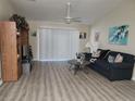 Living room with gray couch, wood floors, and sliding glass doors at 3604 Harvest Orchard Dr, Plant City, FL 33567