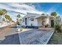 Mobile home on a tree-lined street with a carport and landscaping at 4851 W Gandy Blvd # B6 L3, Tampa, FL 33611