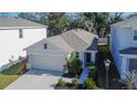 Two-story home with gray siding, two car garage, and landscaping at 5221 Hillside Meadow Pl, Tampa, FL 33610