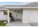 Bright white house exterior with a covered entryway and gray brick walkway at 701 25Th Sw St, Largo, FL 33770