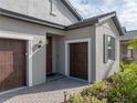 Front entrance and two-car garage with a brick paved walkway at 12626 Tahitian Pearl Cir, Parrish, FL 34219