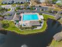 Community pool with lounge chairs and lake view at 12908 Brant Tree Dr, Riverview, FL 33579