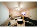 Cozy living room with a large sectional sofa, ceiling fan, and mounted TV at 1330 70Th N St, St Petersburg, FL 33710