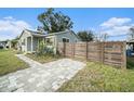 A renovated home with a gray exterior, modern fence, and a paved walkway at 175 83Rd N Ave, St Petersburg, FL 33702