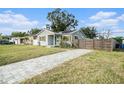 Newly renovated home with a gray exterior, landscaped yard, and modern fence at 175 83Rd N Ave, St Petersburg, FL 33702