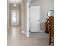 Well-lit hallway featuring tiled flooring and an elegant chandelier, showcasing the home's attention to detail at 1838 Tallulah Ter, Wesley Chapel, FL 33543