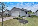 New home exterior, paver driveway, and landscaped yard at 2584 89Th Street E Cir, Palmetto, FL 34221