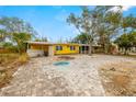 Front view of a yellow house with a spacious driveway at 2812 Miriam S St, Gulfport, FL 33711