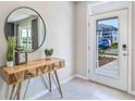 Bright entryway with console table, mirror, and view to backyard at 2875 Gardiner Ln, Zephyrhills, FL 33541