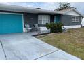 Gray house with teal garage door and small front yard at 3148 Harvardston Loop, Holiday, FL 34691