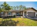 Single-story house with a landscaped yard and a two-car garage at 1597 Franklin Way, Dunedin, FL 34698