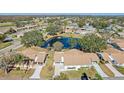 Aerial view of community with pond and numerous homes at 2243 Greenwich Dr, Sun City Center, FL 33573