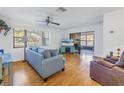 Spacious living room with hardwood floors, blue sofa, and access to a patio at 2530 Oakleaf Ln # 31A, Clearwater, FL 33763