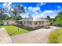 Single story home exterior view, with large yard and driveway at 2818 S 64Th St, Tampa, FL 33619