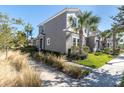 Two-story townhome with a grey exterior and palm trees at 13316 Wildgrass Trl, Odessa, FL 33556