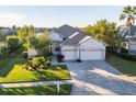 Exterior view of a house with a three-car garage and a basketball hoop at 3115 Bowfin Dr, Land O Lakes, FL 34639