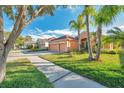 Two-story house on a tree-lined street with a two-car garage and palm trees at 613 Tanana Fall Dr, Ruskin, FL 33570