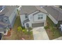 Two-story house with gray roof, driveway, and surrounding houses at 6300 Beverly Hills Dr, Zephyrhills, FL 33541
