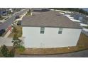Side view of two story house with gray siding and gray roof at 6300 Beverly Hills Dr, Zephyrhills, FL 33541