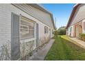 Side view of the house showcasing gray shutters and landscaping at 3340 Mcmath Dr, Palm Harbor, FL 34684