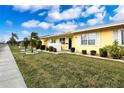 Side view of a yellow house with landscaping and street view at 1005 Rickenbacker Dr, Sun City Center, FL 33573