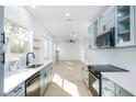 Modern kitchen with light gray cabinets, quartz countertops, and stainless steel appliances at 1045 22Nd N Ave, St Petersburg, FL 33704