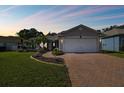 Well-maintained house with a landscaped yard and a brick paved driveway at 11411 Turtle Dove Pl, New Port Richey, FL 34654