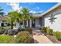 Inviting front porch with palm trees and a walkway to the front door at 11411 Turtle Dove Pl, New Port Richey, FL 34654