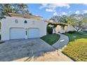 Front view of a two-story house with a two-car garage and walkway at 14157 Feather Sound Dr, Clearwater, FL 33762