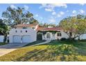 Spanish style home with a red tile roof and a large front yard at 14157 Feather Sound Dr, Clearwater, FL 33762